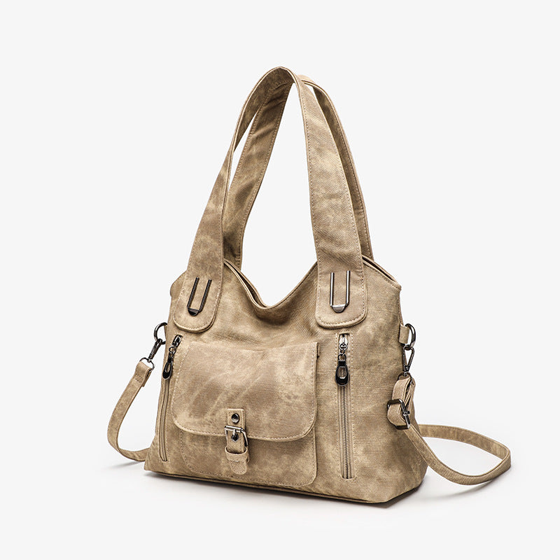 Beige handbag with multiple pockets and straps on a white background