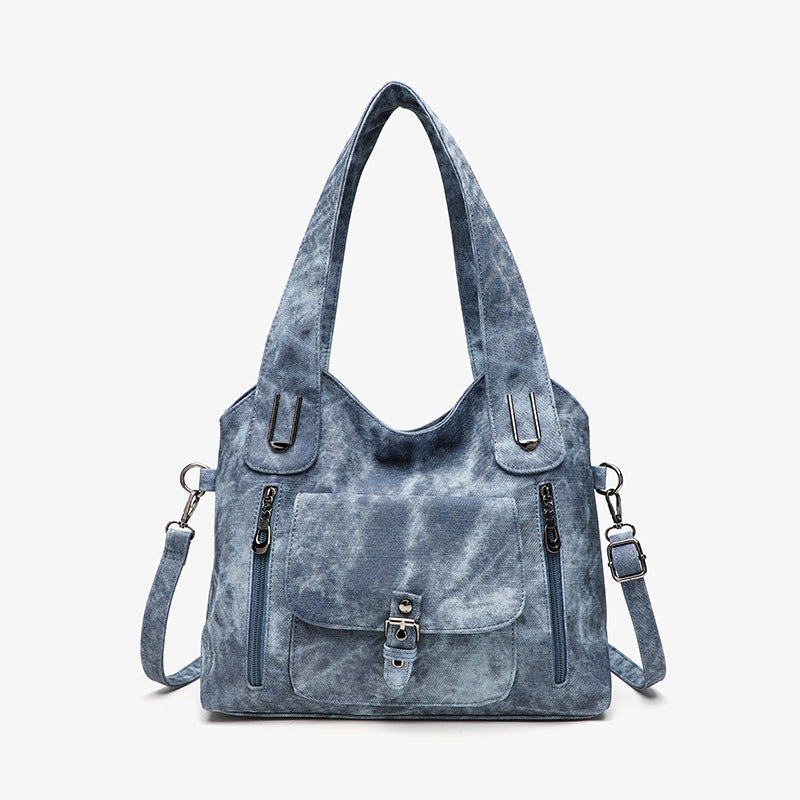 Blue tie-dye handbag with multiple pockets and straps on a white background