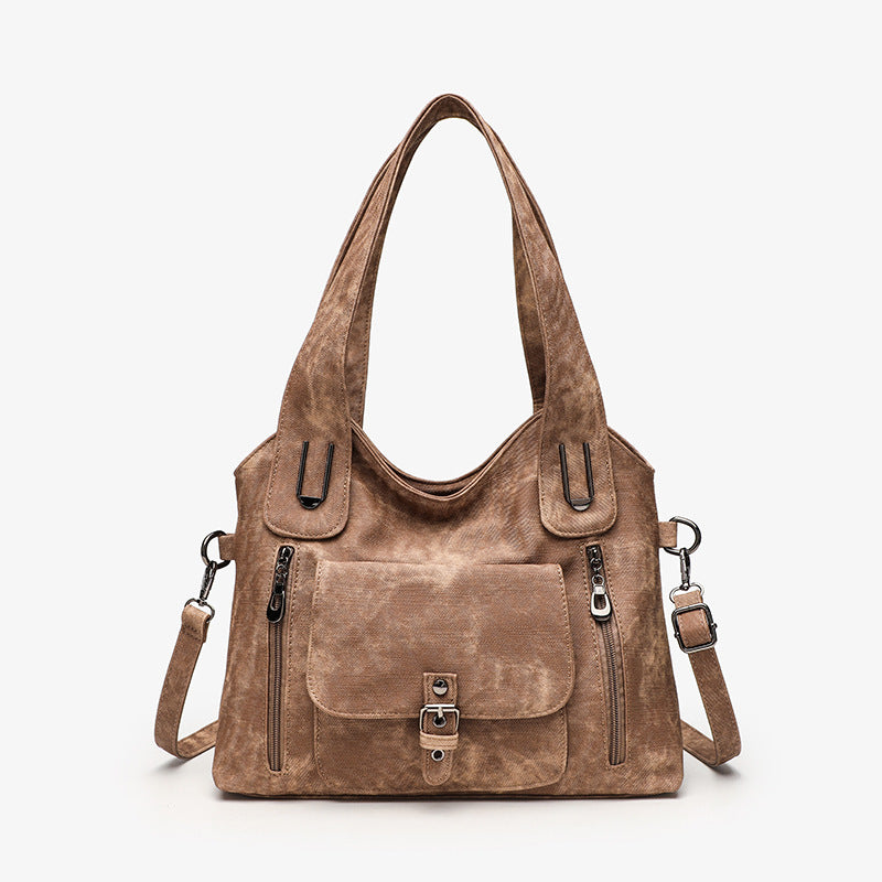 Brown leather handbag with multiple pockets and straps on a white background