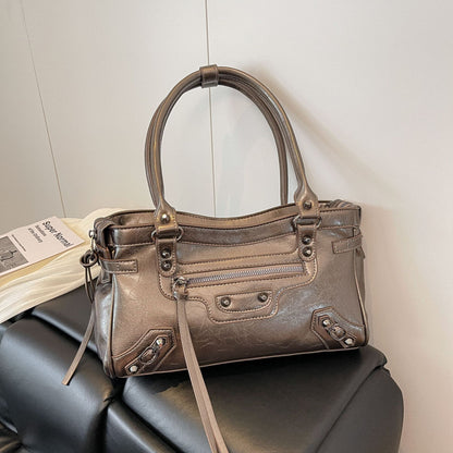 Brown handbag on a black surface with a light gray background