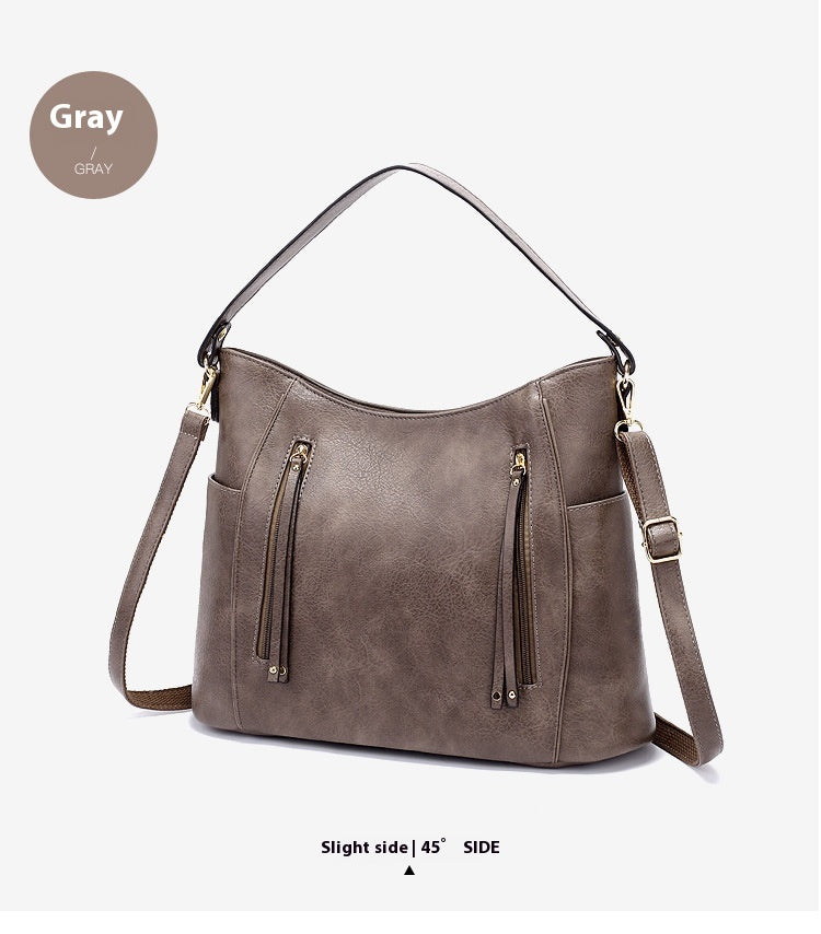 Gray handbag with zippers on a white background