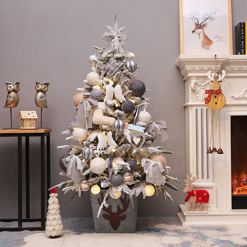 Decorated Christmas tree in a room with a fireplace and decorative items.